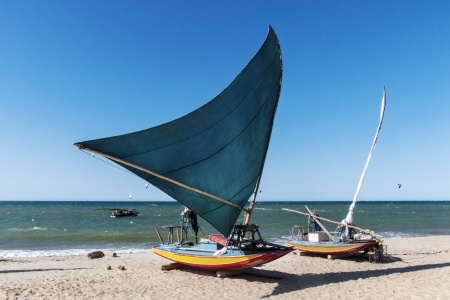 Two sail boats sit on the beach in Jericoacoara. 