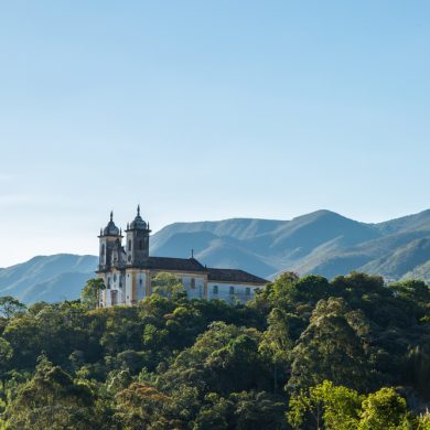 A shot of Ouro Preto church from afar, forest covers the lower part of the photo.