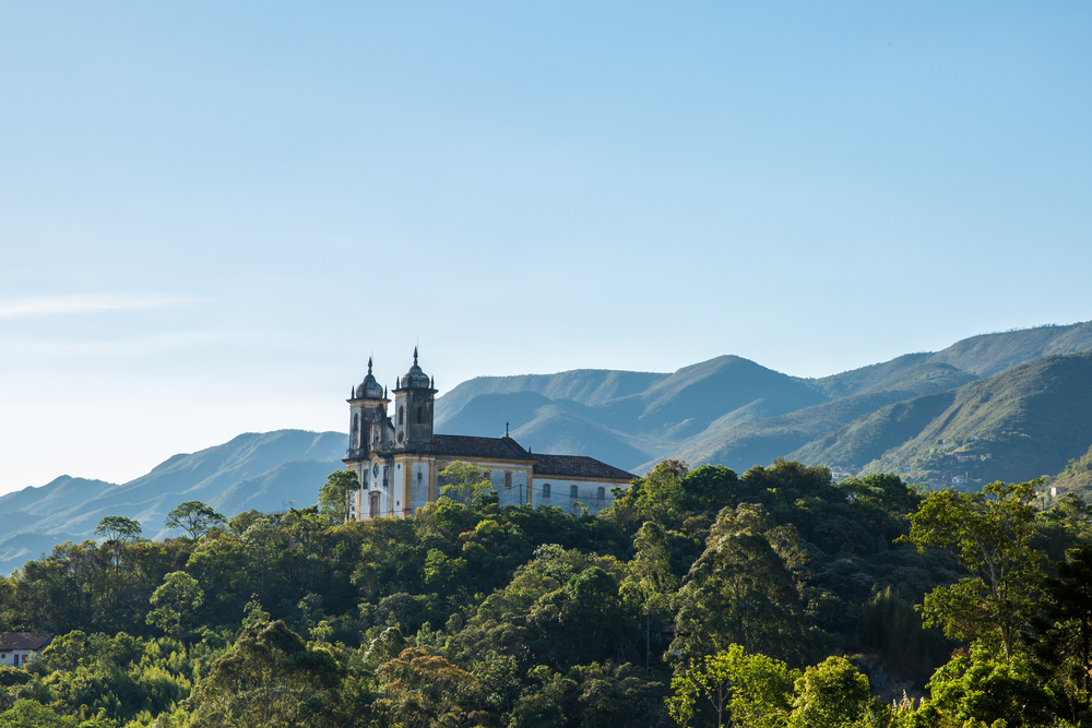 A shot of Ouro Preto church from afar, forest covers the lower part of the photo.