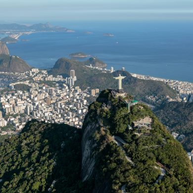 Aerial view of Corcovado from above and behind showing the entire bay of Rio de Janeiro in the background.