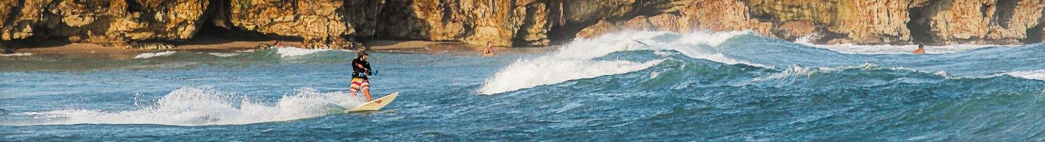Panoramic shot of Kitesurfer with cliffs in the background.