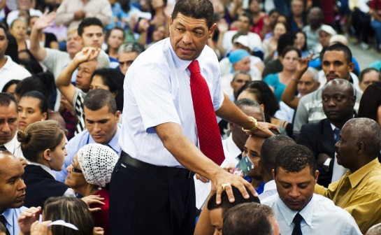 Pastor Valdemiro places his hands on followers heads.