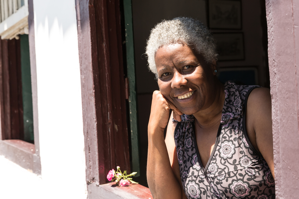 Woman smiles from her open window in Minas Gerais.